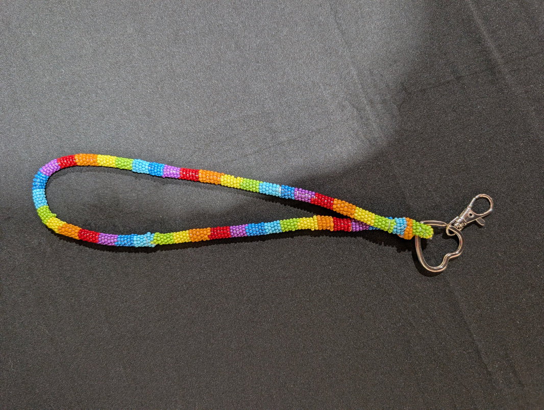 Multicolored lanyard with a metal clip on a gray background