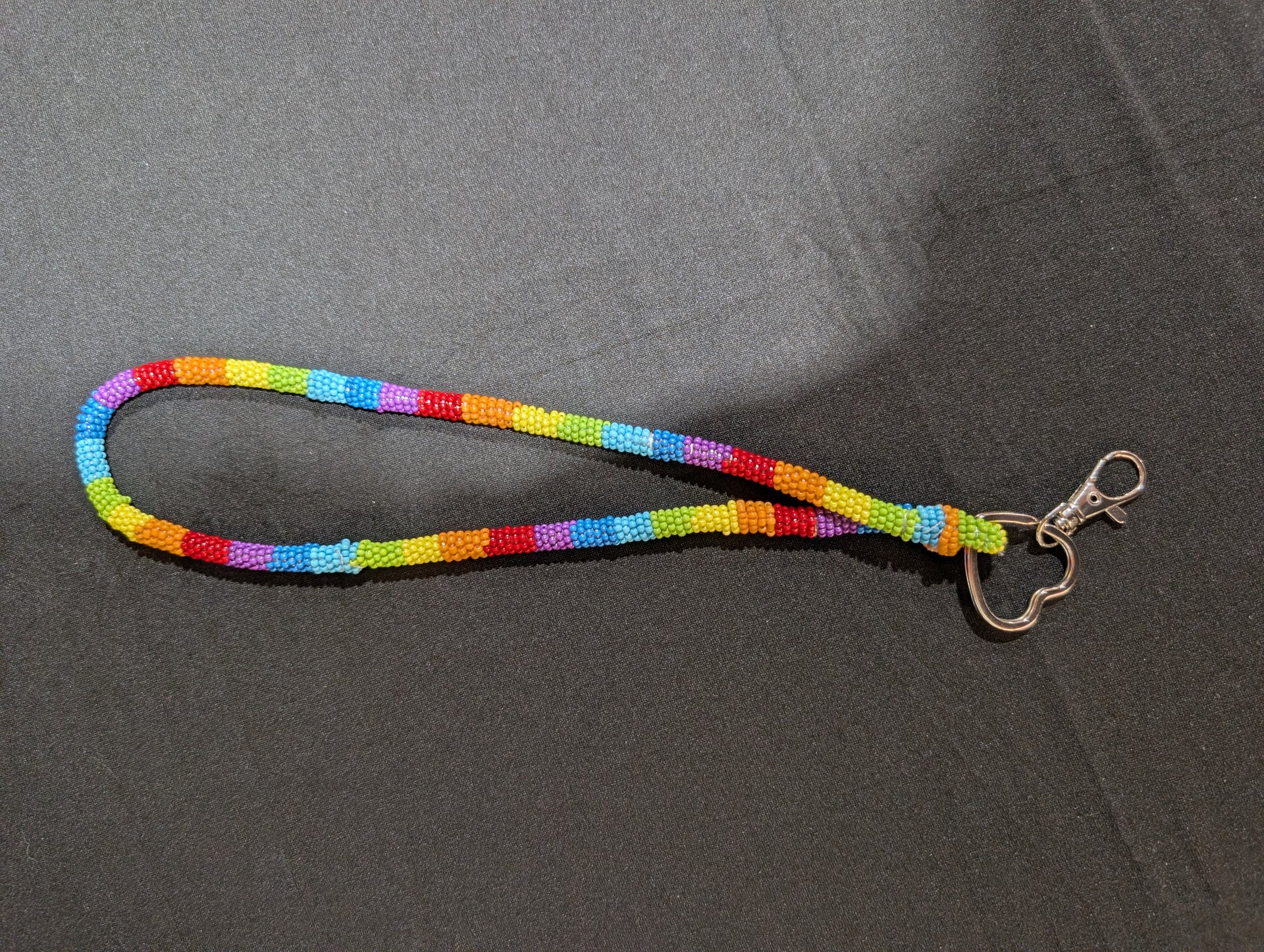 Multicolored lanyard with a metal clip on a gray background
